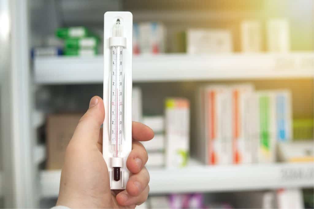 Manual Thermometer being held up with Medication